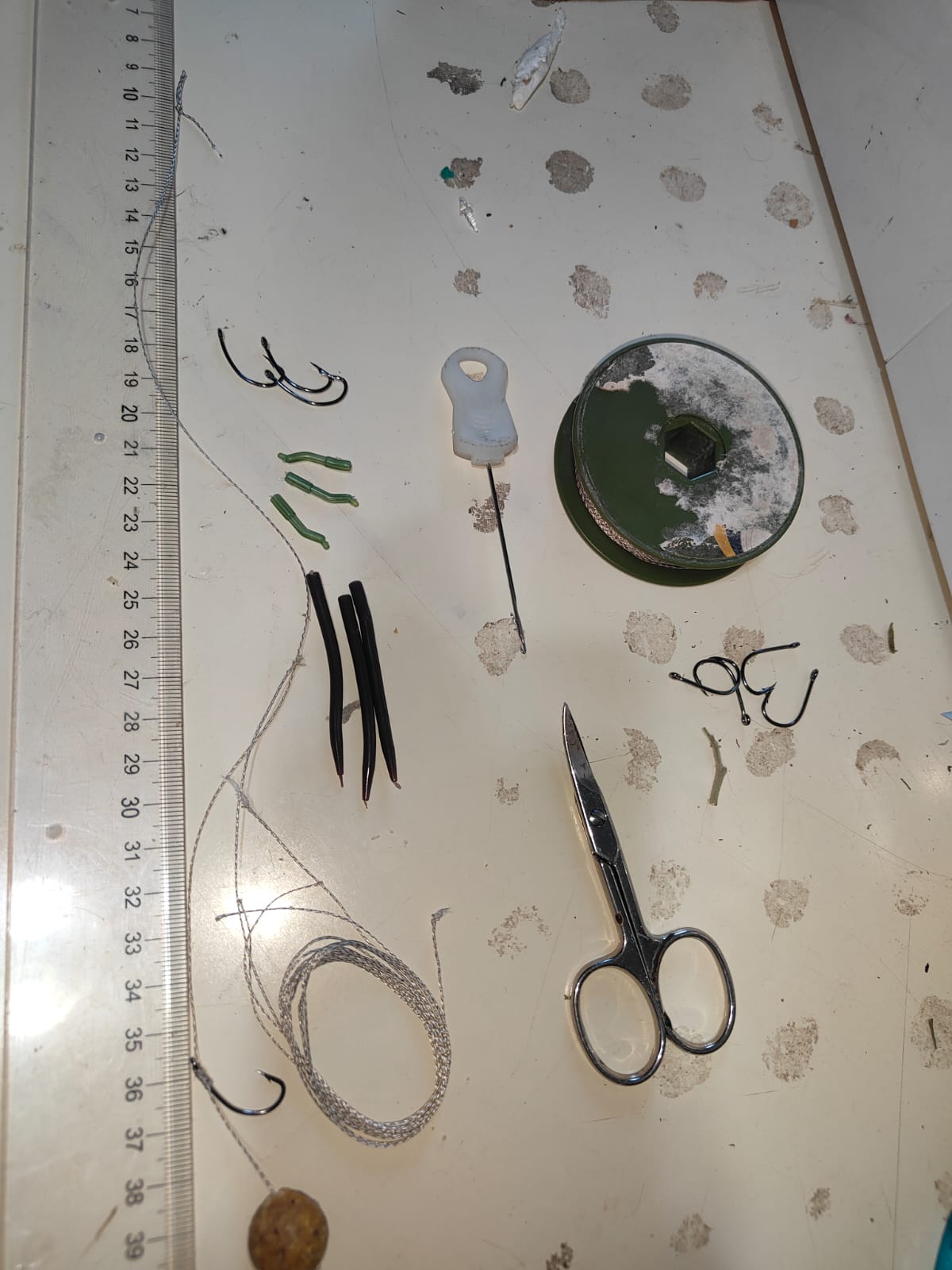 Materiales de montaje de bajos de carpfishing sobre una mesa