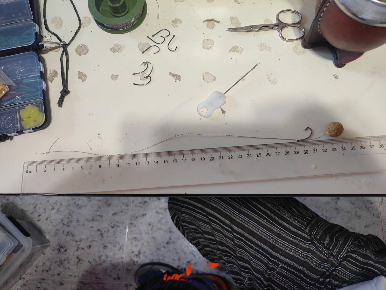 Bajo completo de carpfishing con hair rig y boilie sobre una regla